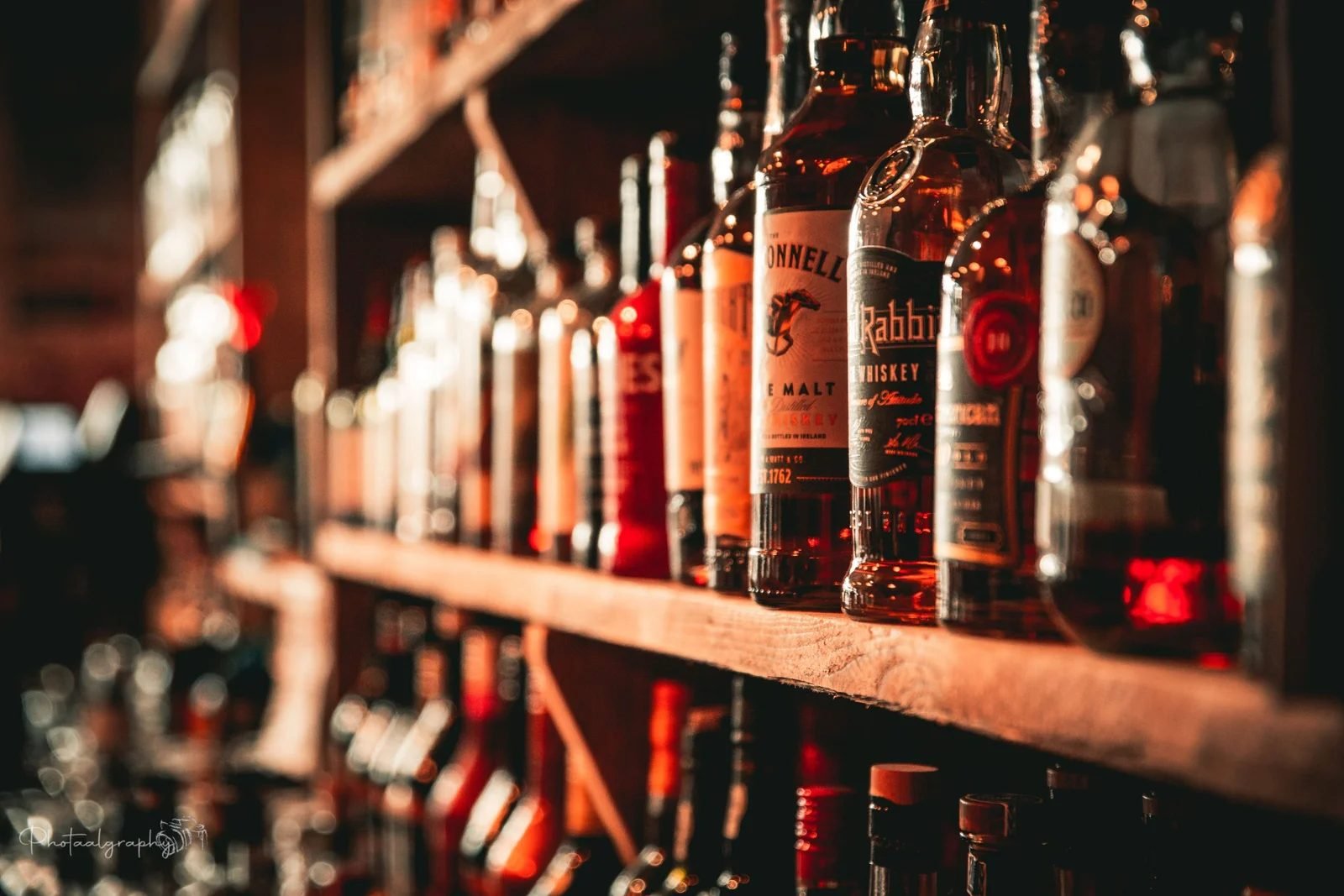 Wand vol Ierse whiskeyflessen bij Murray's
